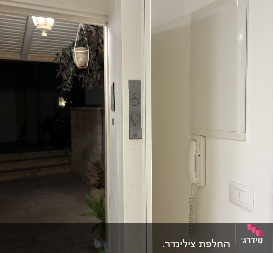 דלת פתוחה עם מנעול וידית, טלפון קיר